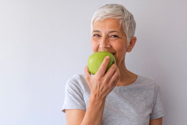 Longevity woman eating an apple