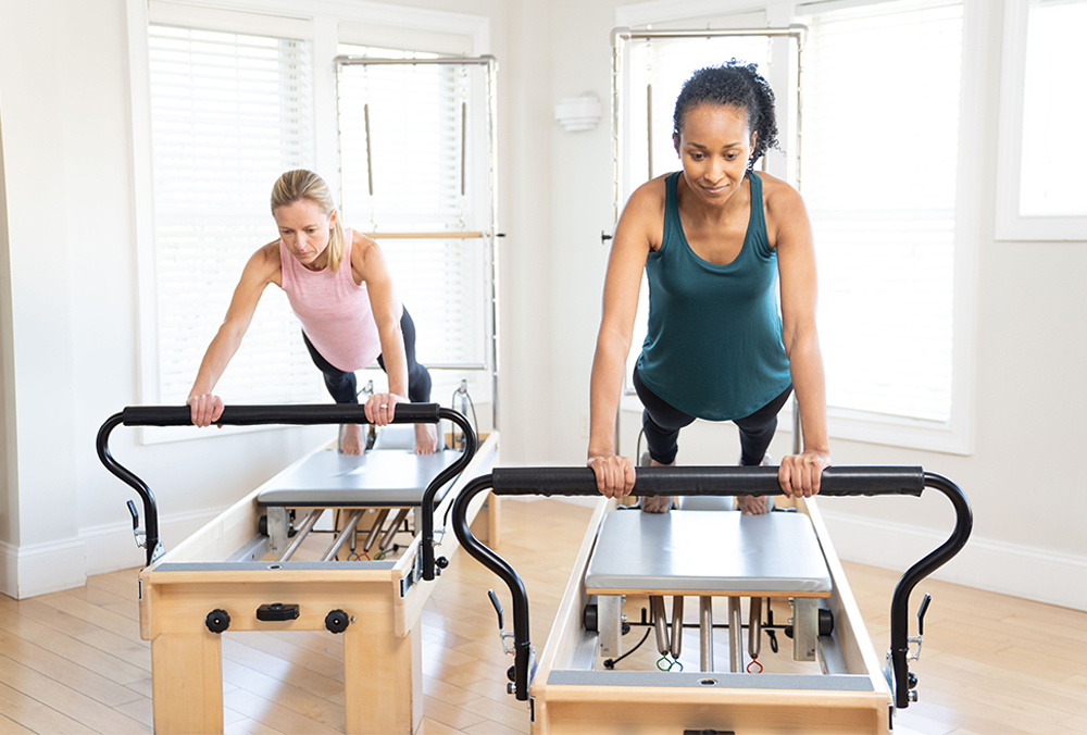 Pilates hero two women on a reformer pilates