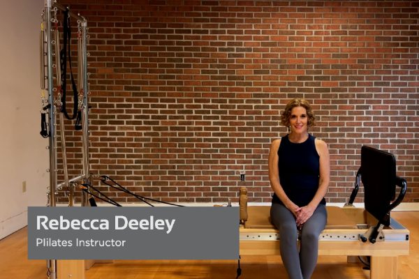 Pilates Instructor Rebecca Deeley sitting on a Pilates Reformer