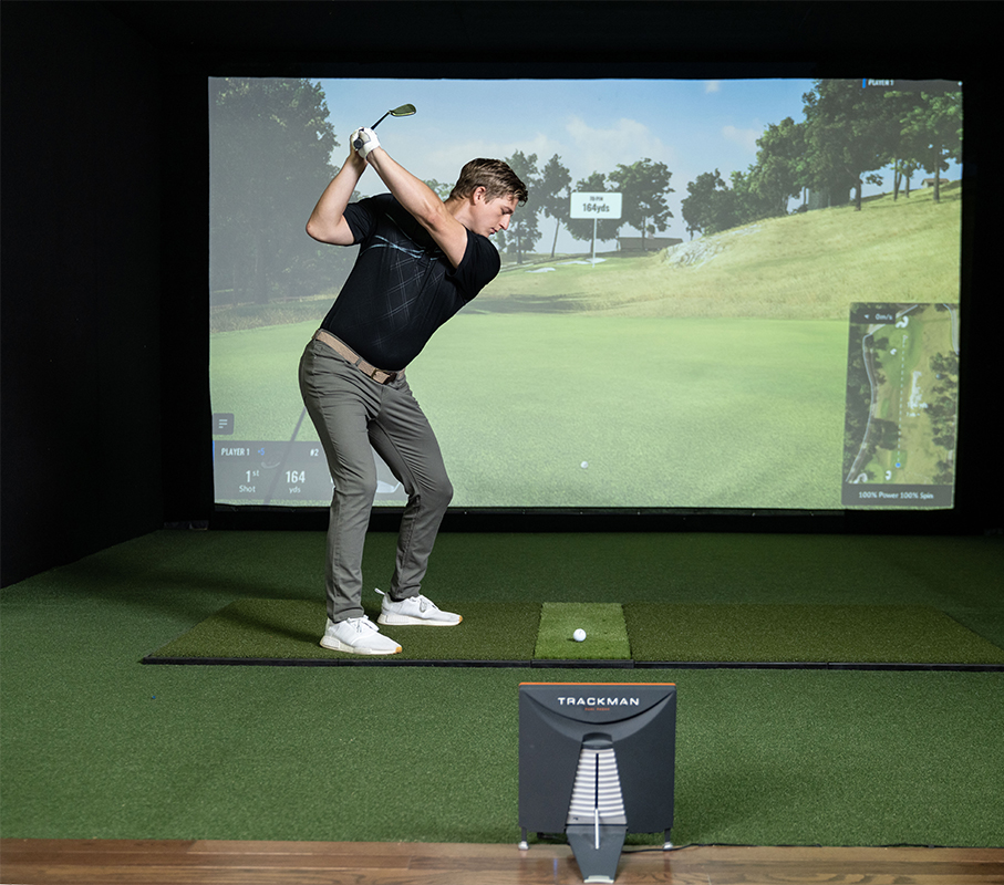 man swinging a golf club on a golf simulator