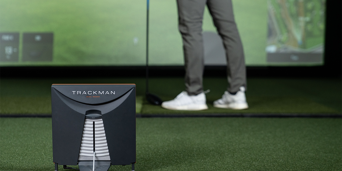 golfer standing in front of the TrackMan golf simulator