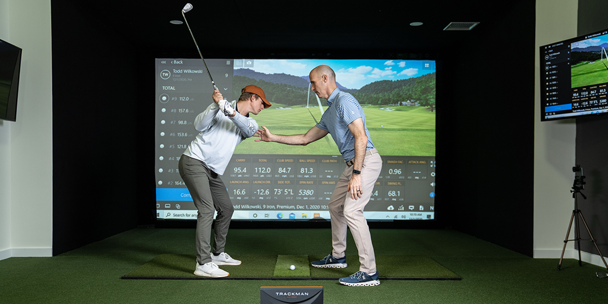 TPI expert coaches a client to get the best swing on the golf simulator