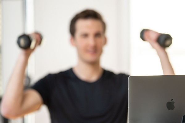 man working out in front of a laptop