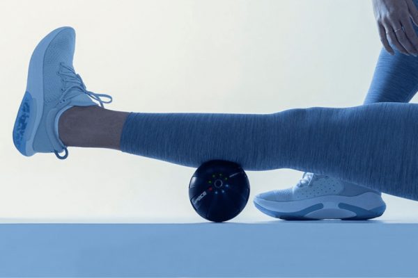 Woman using a Hyperice roller on her calf