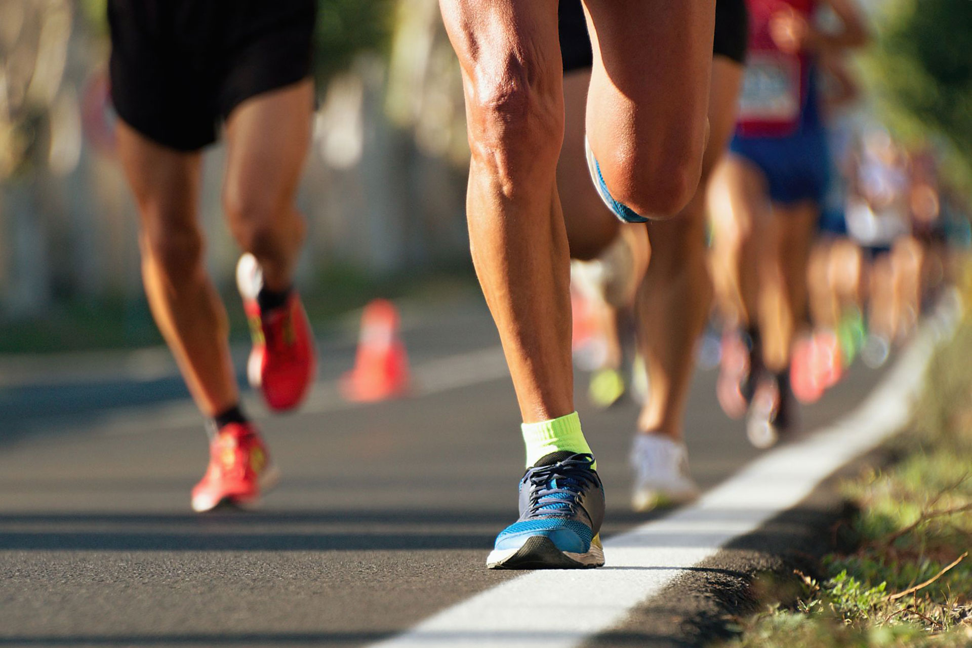 Measuring The Running Speed Of An Athlete Using A Mechanical Stopwatch.  Hand With A Stopwatch On The Background Of The Legs Of A Runner. Stock  Photo, Picture and Royalty Free Image. Image