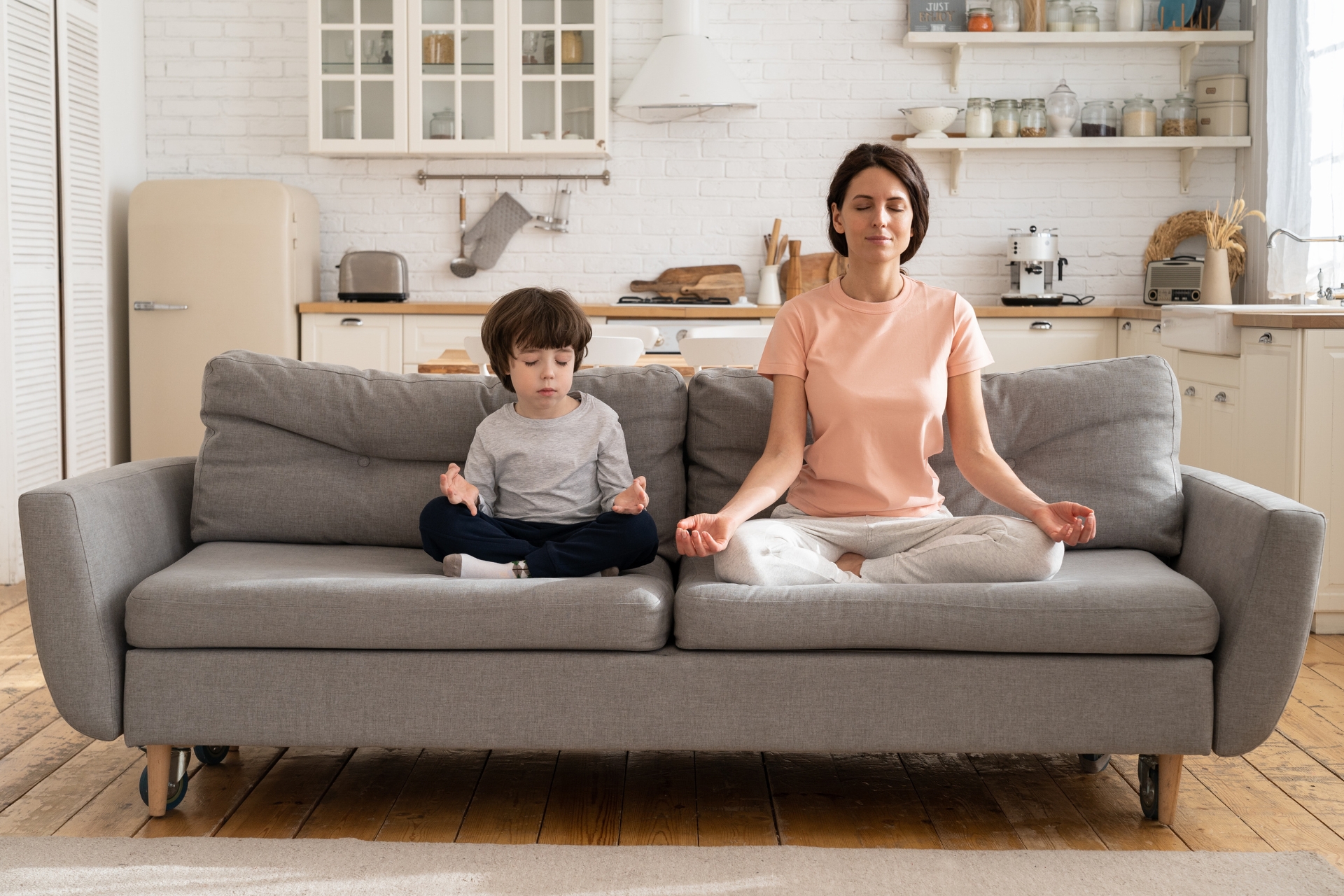 mom meditating with her son on the couch
