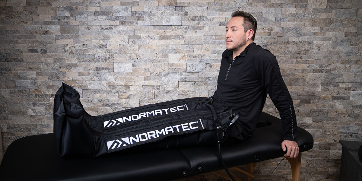 man in normatec boots