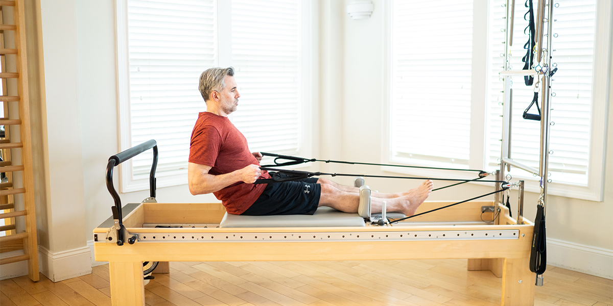 man rowing on a Pilates Reformer