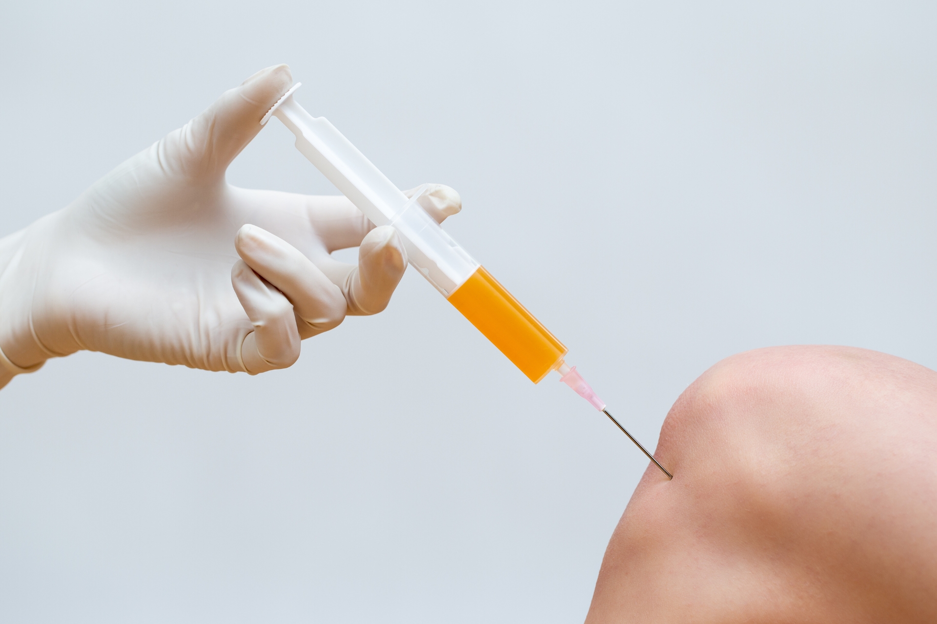 Doctor injecting stem cells into a knee